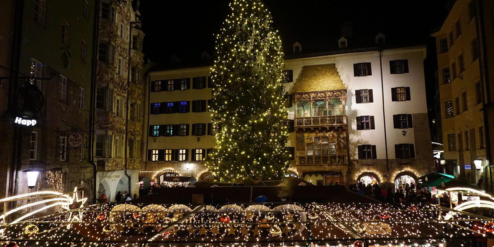 The Christmas tree and market stalls in front of the Golden Roof in Innsbruck old town at night