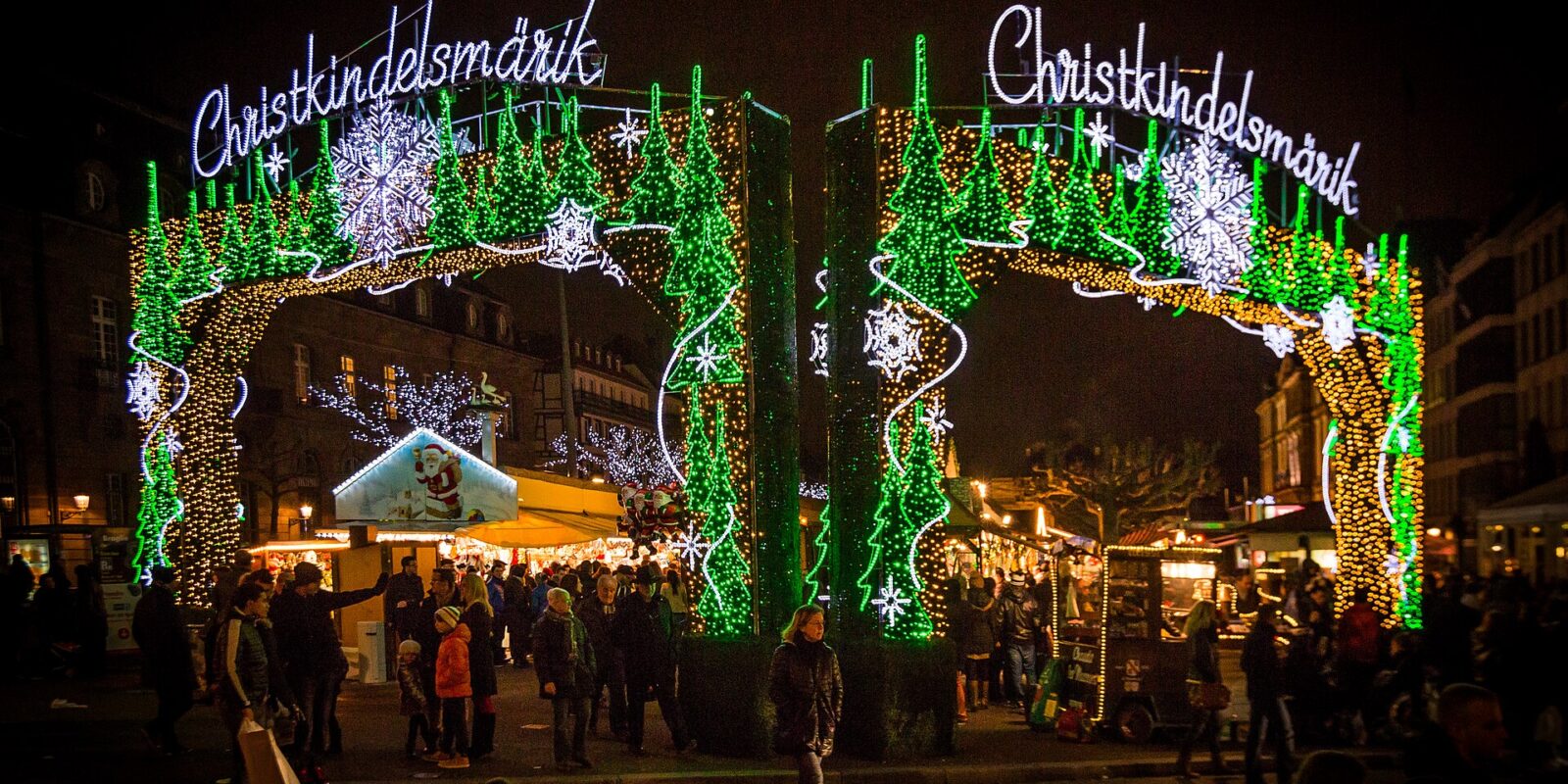 Illuminated Christkindelsmärik arches at the entrance to the Strasbourg Christmas market at night